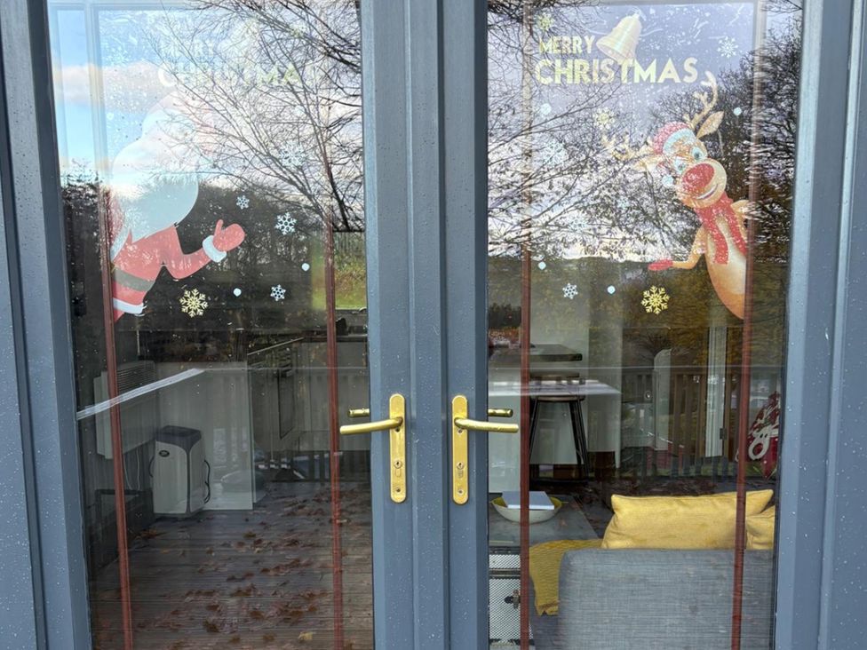 A door with Christmas decorations featuring Santa Claus and Rudolph at Pet Friendly 2-Bed Lodge, Sleeps 5, Pool & Parking, Caernarfon