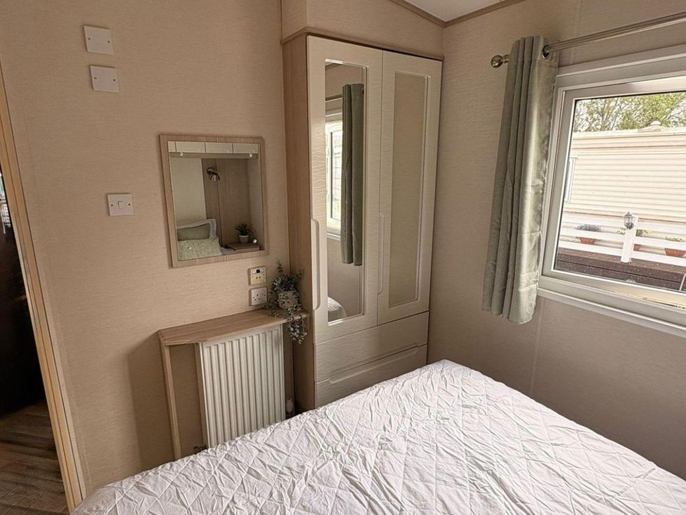 A bedroom with a bed and wardrobe at Caravan - Sleeps 8 - Parking in Northampton
