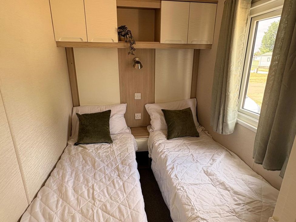 A bedroom with two single beds and a window at Caravan - Sleeps 8 - Parking in Northampton