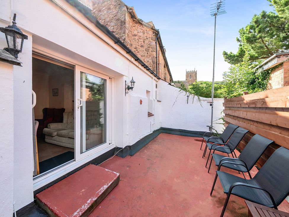 An outdoor area with chairs and a view of a building at House in historic village - Sleeps 6 Dunster