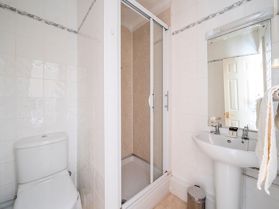 A bathroom with toilet, shower, sink, and mirror at House in historic village - Sleeps 6 Dunster