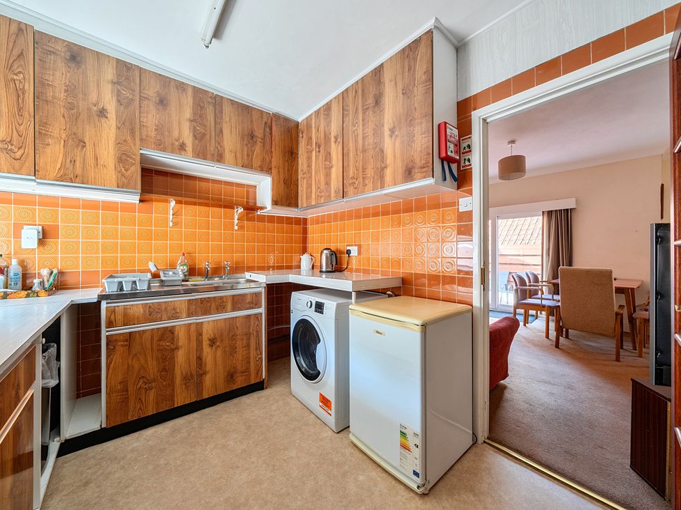 A kitchen with wood cabinets and a washing machine at House in historic village - Sleeps 6, Dunster