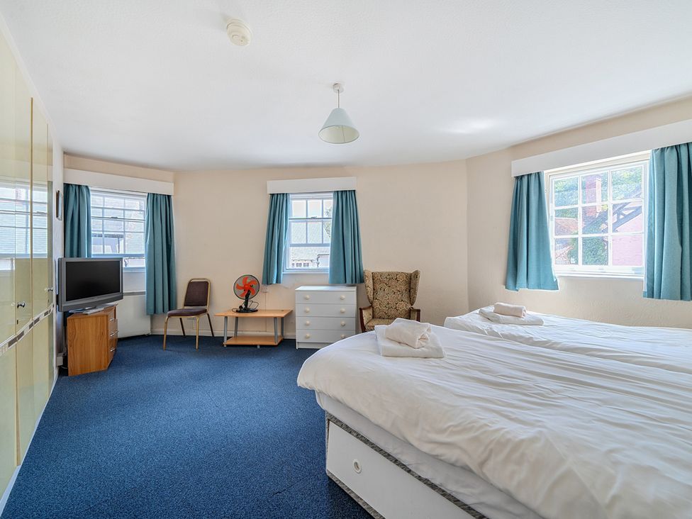 A bedroom with two beds and a chair at House in historic village - Sleeps 6 Dunster