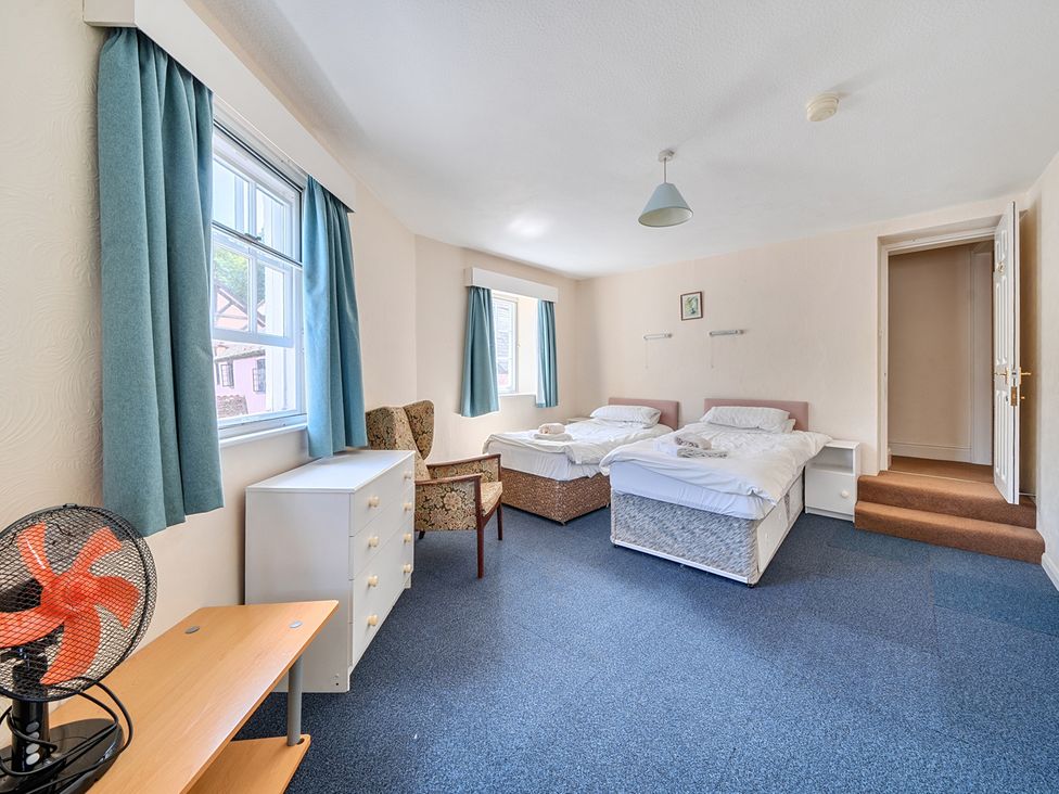 A bedroom with two beds and a chair at House in historic village - Sleeps 6 Dunster