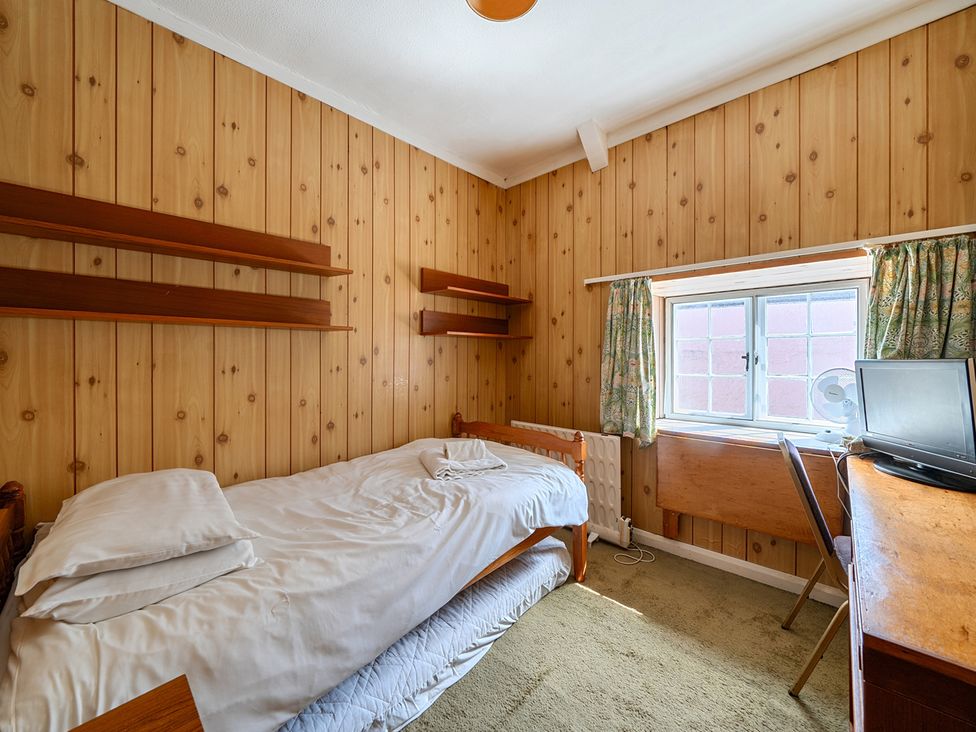 A bedroom with a bed, desk, and window at House in historic village - Sleeps 6, Dunster