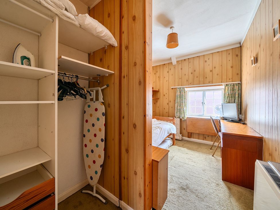 A bedroom with an iron, ironing board, and desk at House in historic village - Sleeps 6, Dunster