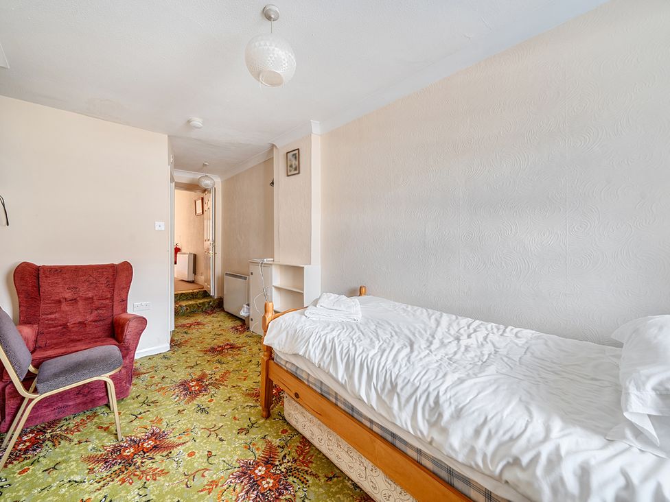 A bedroom with a single bed and armchair at House in historic village - Sleeps 6 Dunster