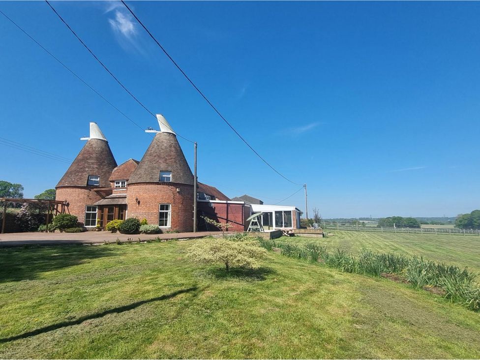 An oast house with a garden and field in Peasmarsh