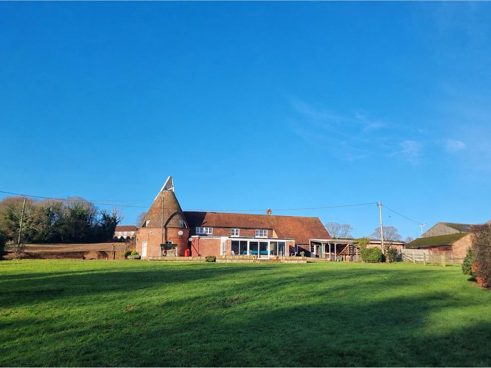 A house with a garden and outbuilding at Sharvels Oast House - Pool, Tennis, Luxury Home Peasmarsh