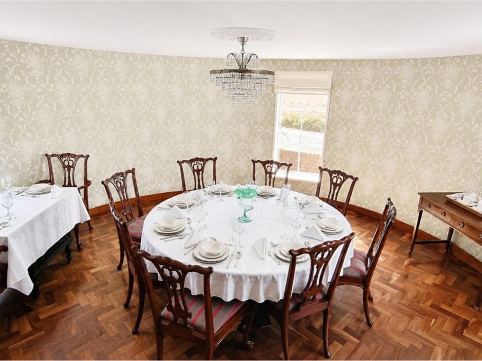 A dining room with a large table set for a meal at Sharvels Oast House - Pool, Tennis, Luxury Home, Peasmarsh