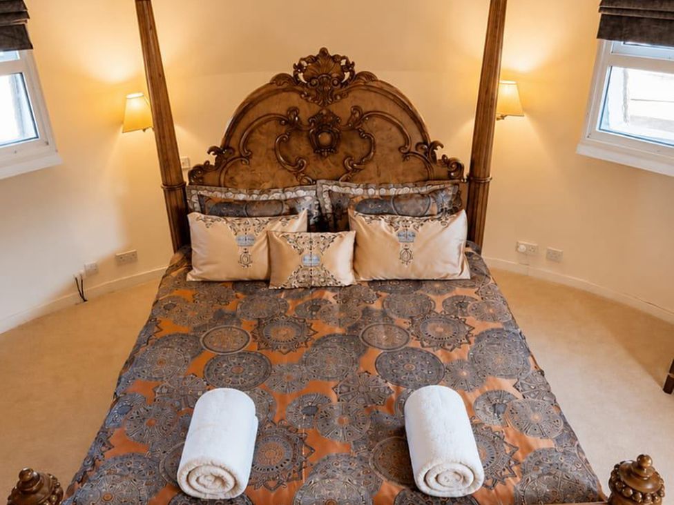 A bedroom with a king-sized bed and decorative pillows at Sharvels Oast House - Pool, Tennis, Luxury Home, Peasmarsh
