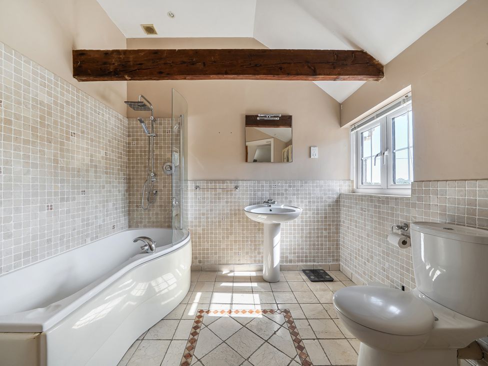 A bathroom with a bathtub, shower, sink, and toilet at Sharvels Oast House - Pool, Tennis, Luxury Home Peasmarsh