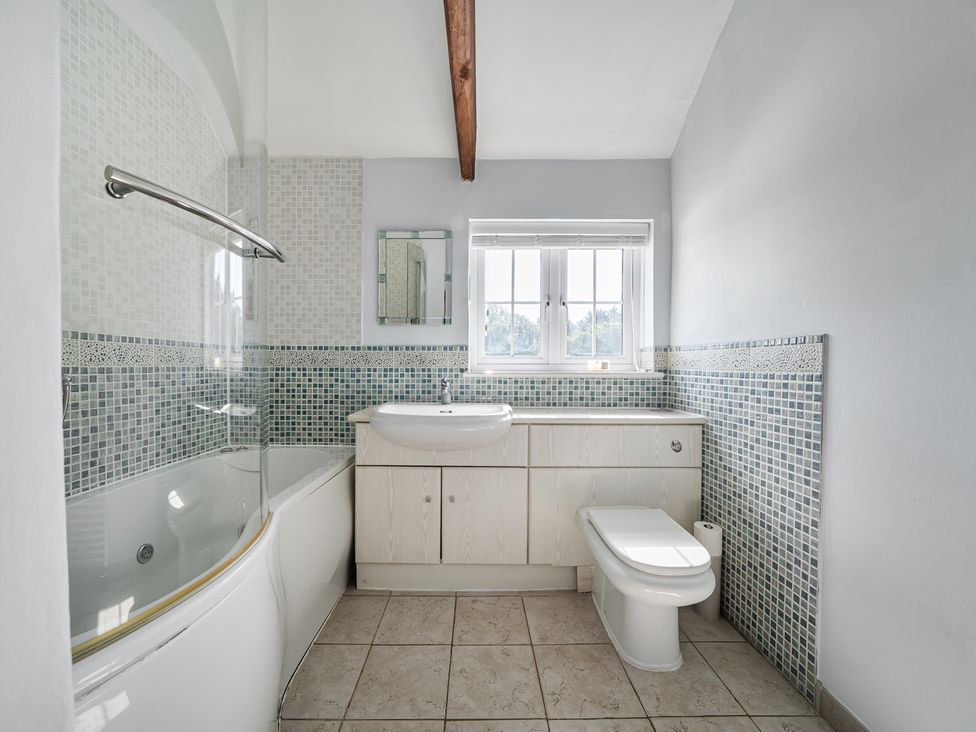A bathroom with a bathtub, toilet, and sink at Sharvels Oast House - Pool, Tennis, Luxury Home in Peasmarsh