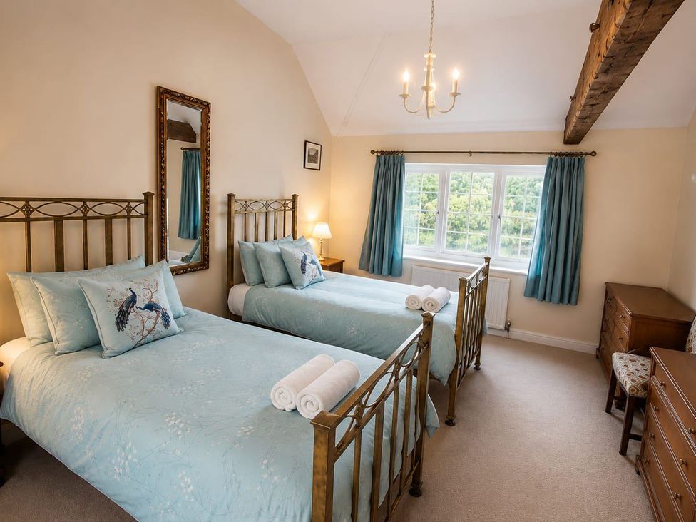 A bedroom with two beds and a window at Sharvels Oast House - Pool, Tennis, Luxury Home, Peasmarsh