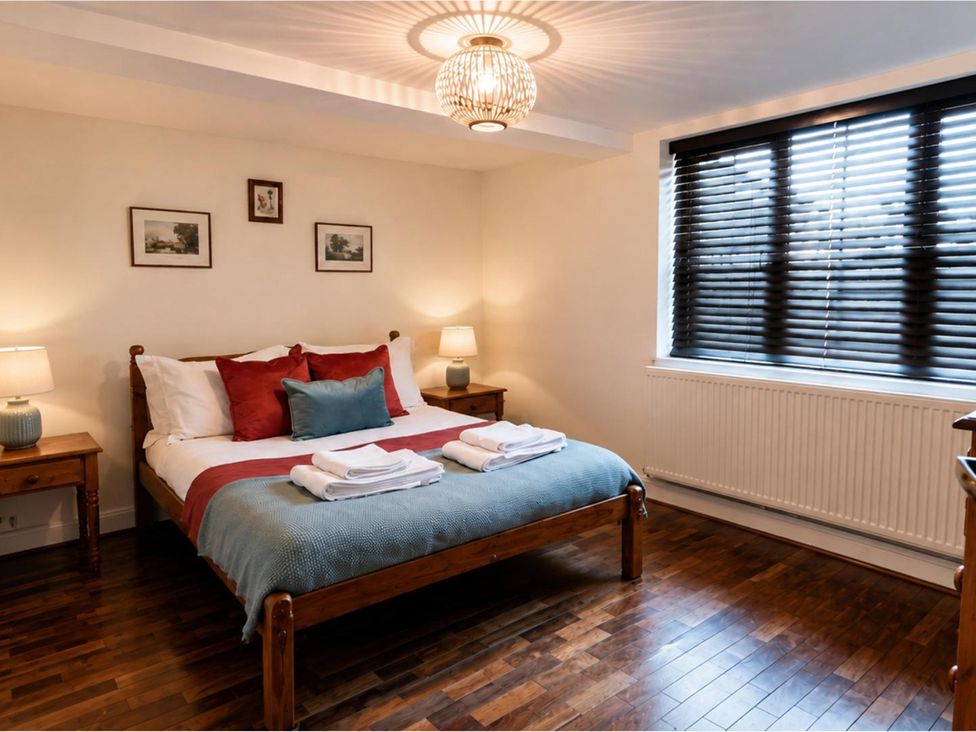 A bedroom with a bed and nightstands at Sharvels Oast House - Pool, Tennis, Luxury Home in Peasmarsh