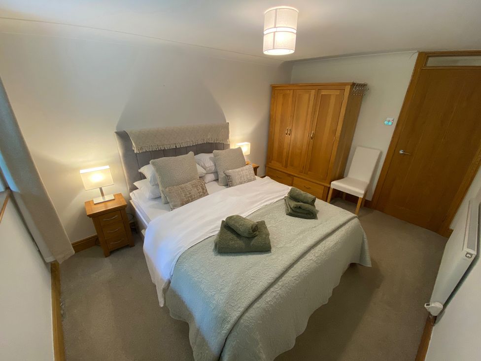 A bedroom with a bed and wardrobe at Quiet, Modern Ground Floor Annex Near Theatr Clwyd, Sychdyn