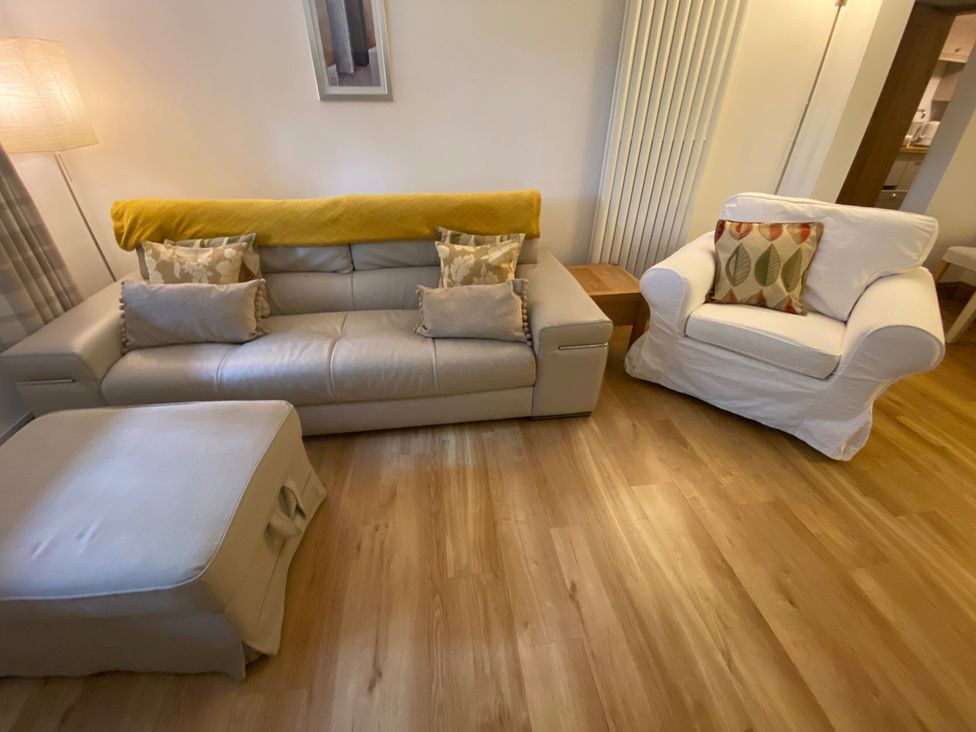 A living room with a sofa and armchair at Quiet, Modern Ground Floor Annex Near Theatr Clwyd, Sychdyn