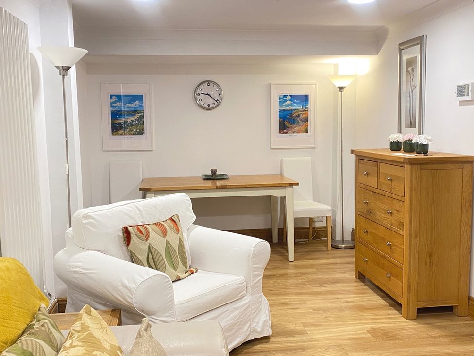 A living room with a sofa, table, and lamp at Quiet, Modern Ground Floor Annex Near Theatr Clwyd, Sychdyn
