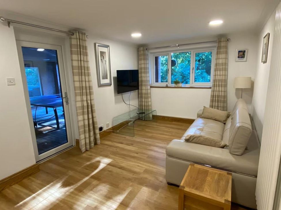 A living room with a couch and television at Quiet, Modern Ground Floor Annex Near Theatr Clwyd, Sychdyn