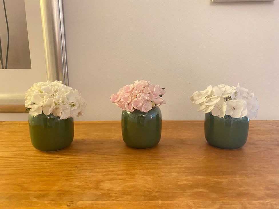 A flower arrangement in vases on a table at Quiet, Modern Ground Floor Annex Near Theatr Clwyd, Sychdyn