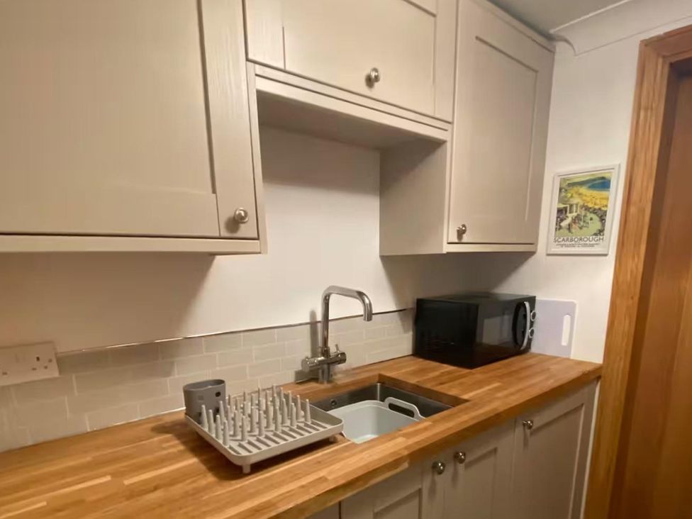 A kitchen with a sink and microwave at Quiet, Modern Ground Floor Annex Near Theatr Clwyd, Sychdyn