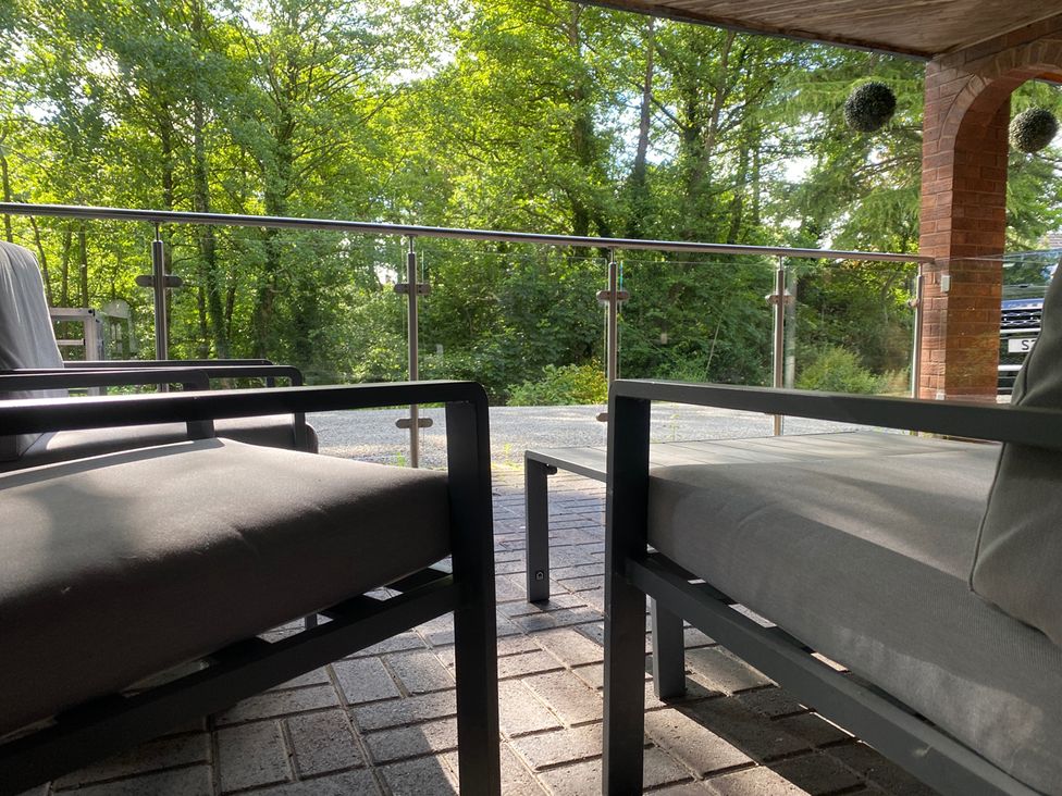 An outdoor seating area with chairs and a table at Quiet, Modern Ground Floor Annex Near Theatr Clwyd Sychdyn
