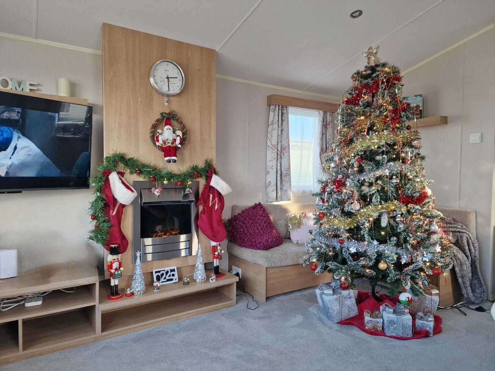A living room with a Christmas tree and decorations at Seafront Caravan - Golden Sands - 6 Berth by Your Away Stays Kinmel Bay