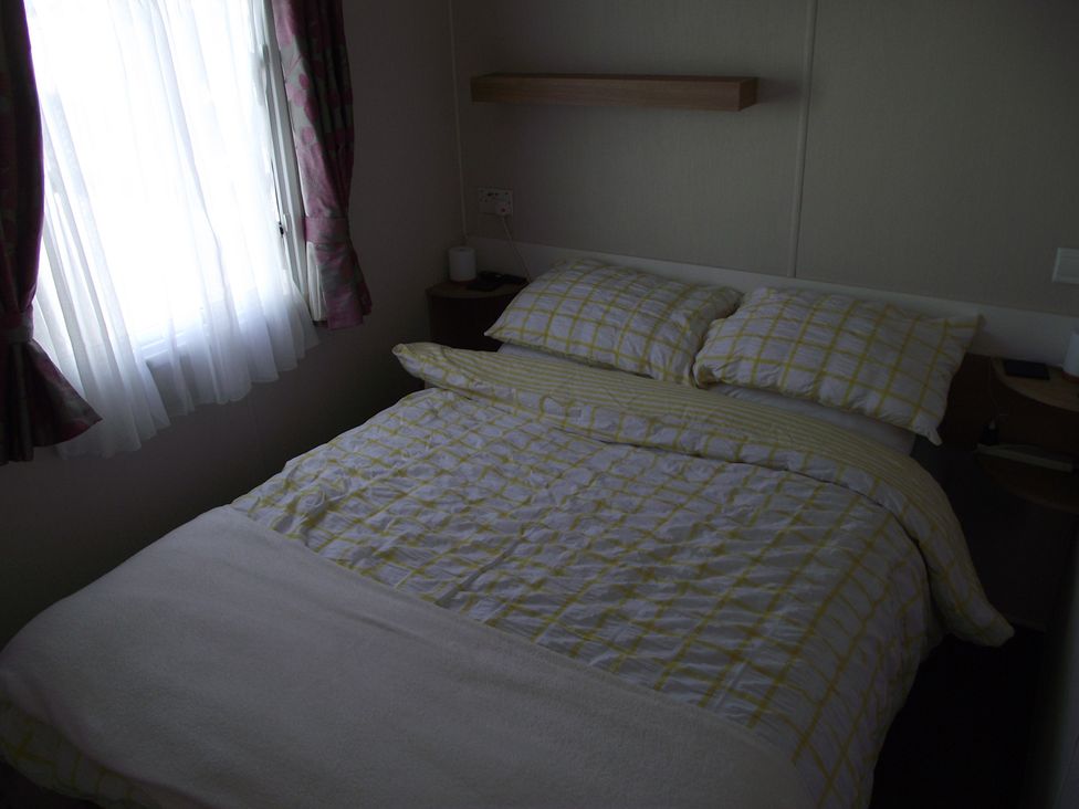 A bedroom with a bed and pillows at Seafront Caravan - Golden Sands - 6 Berth by Your Away Stays, Kinmel Bay