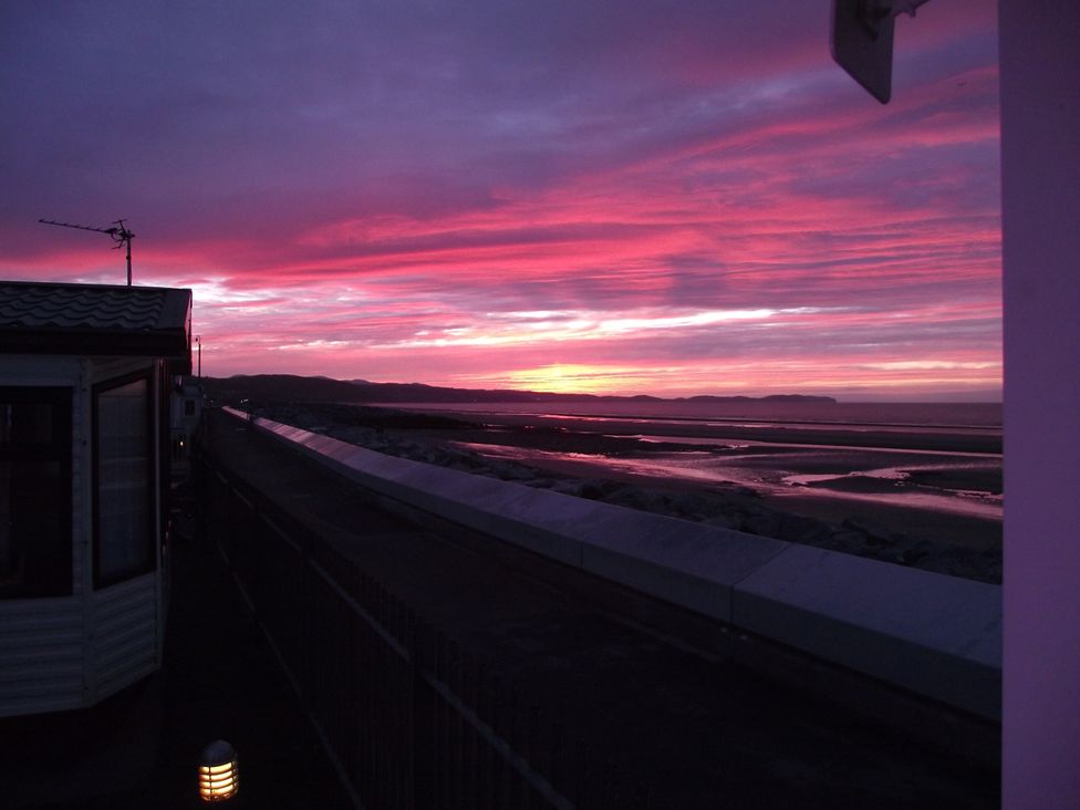 A sunset view with a caravan in the foreground at Seafront Caravan - Golden Sands - 6 Berth by Your Away Stays, Kinmel Bay