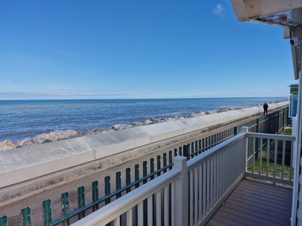 A view of the sea and rocks from a balcony at Seafront Caravan - Golden Sands - 6 Berth by Your Away Stays in Kinmel Bay