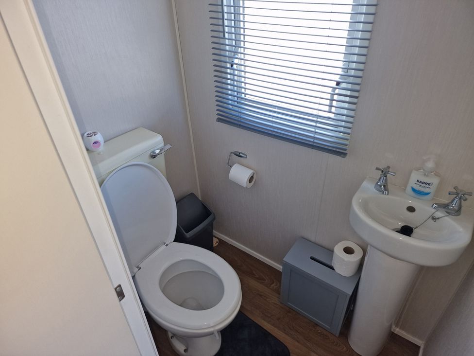A bathroom with a toilet and sink in Seafront Caravan - Golden Sands - 6 Berth by Your Away Stays Kinmel Bay