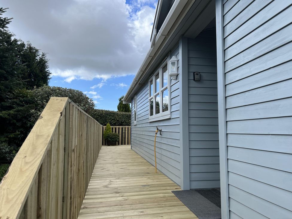 A wooden deck leading to an entrance at Holly Blue - Cosy wooden lodge, Kippford