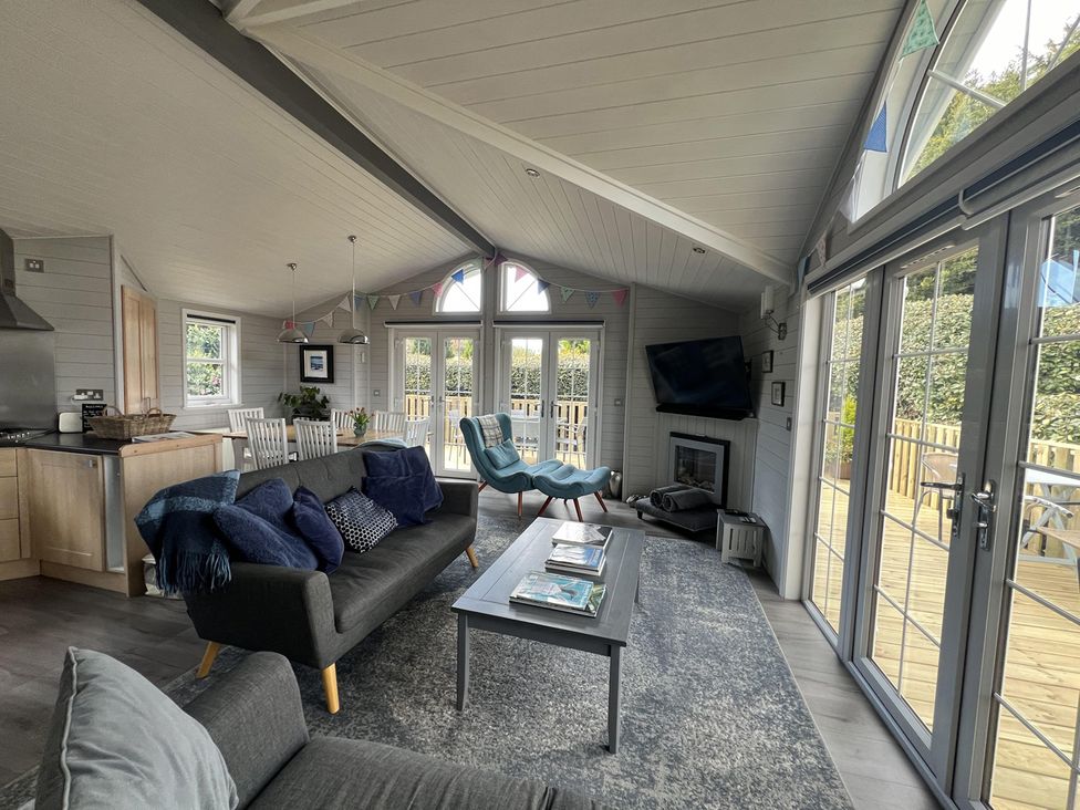 A living room with a sofa and coffee table at Holly Blue - Cosy wooden lodge, Kippford