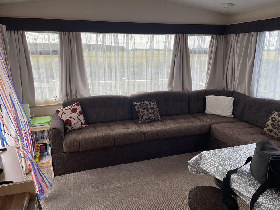 A snug with a brown sofa and table at 4 Bed Lodge Sleeps 8 - Pets & WiFi Free Parking in Ingoldmells