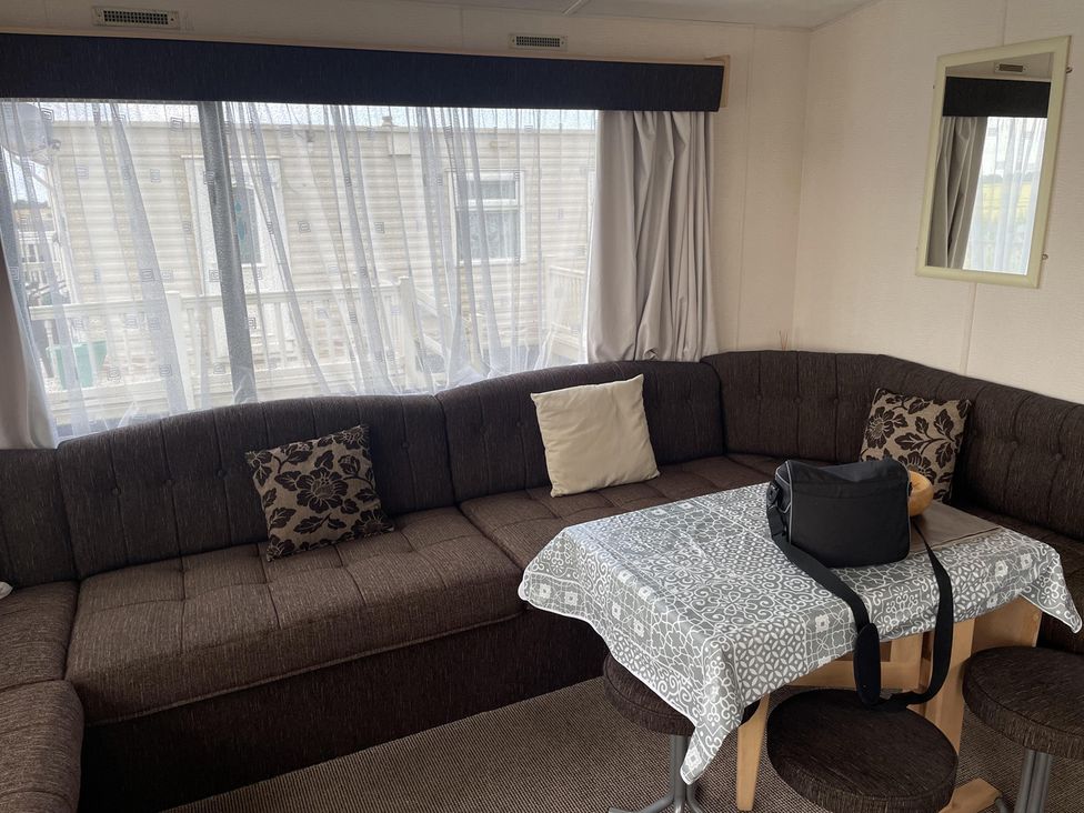 A living room with a sectional sofa and table at 4 Bed Lodge Sleeps 8 - Pets & WiFi Free Parking in Ingoldmells
