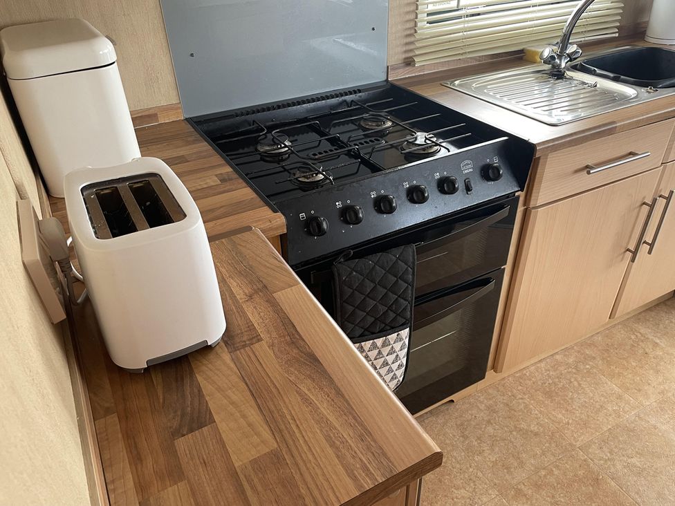 A kitchen with a gas stove and a toaster at 4 Bed Lodge Sleeps 8 - Pets & Free Parking in Ingoldmells