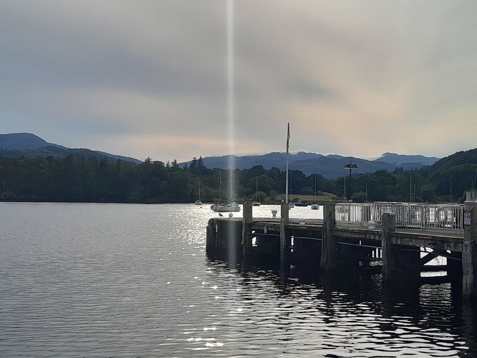 A pier over water with boats in the distance at Ye Old'e Man - Sleeps 6 & Pet Friendly Near Flookburgh