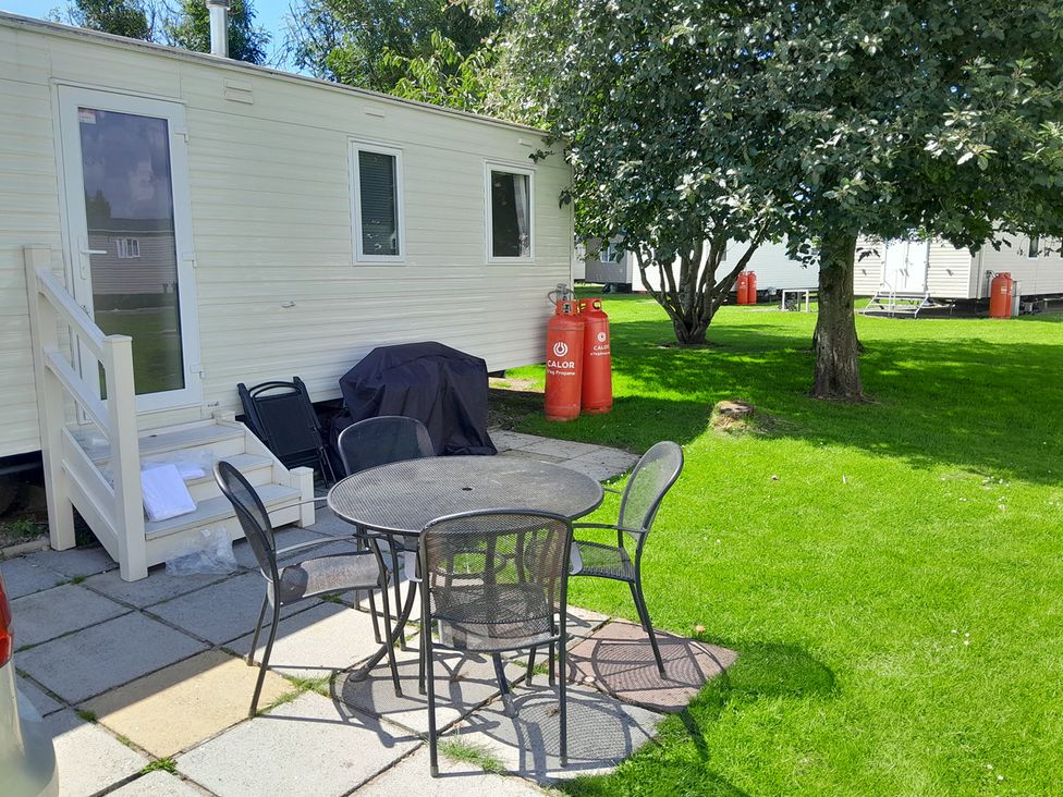 An outdoor seating area with a table and chairs at Ye Old'e Man - Sleeps 6 & Pet Friendly, Near Flookburgh