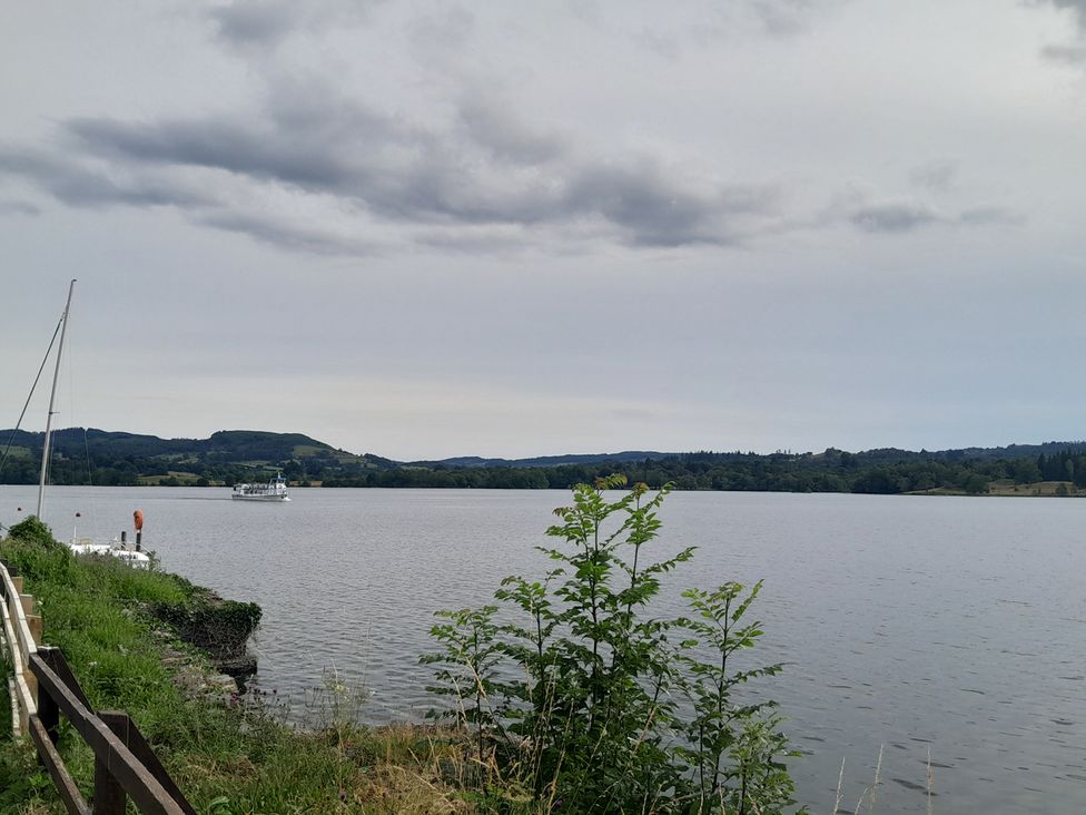 A view of a lake with a boat and greenery at Ye Old'e Man - Sleeps 6 & Pet Friendly near Flookburgh