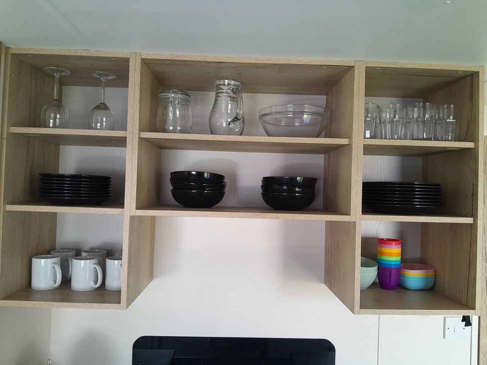 A kitchen shelf with various glassware and dishware at Ye Old'e Man - Sleeps 6 & Pet Friendly, Near Flookburgh