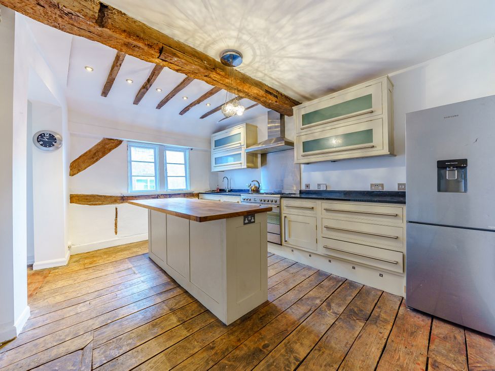 A kitchen featuring wooden beams and an island at 4BedHouse in Leominster