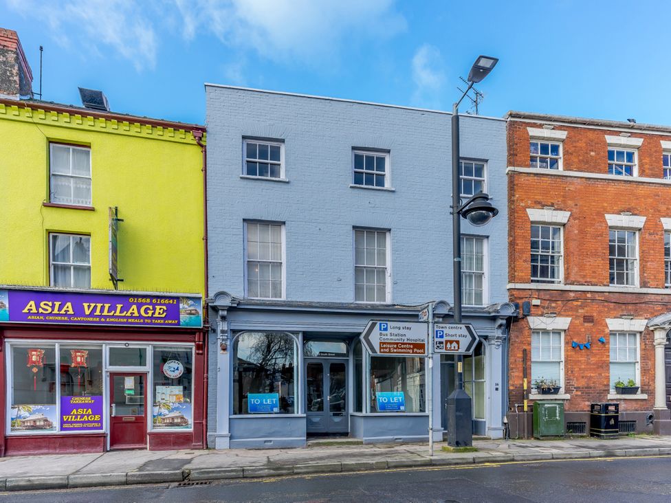 A commercial building with restaurant signage and for rent sign in Leominster