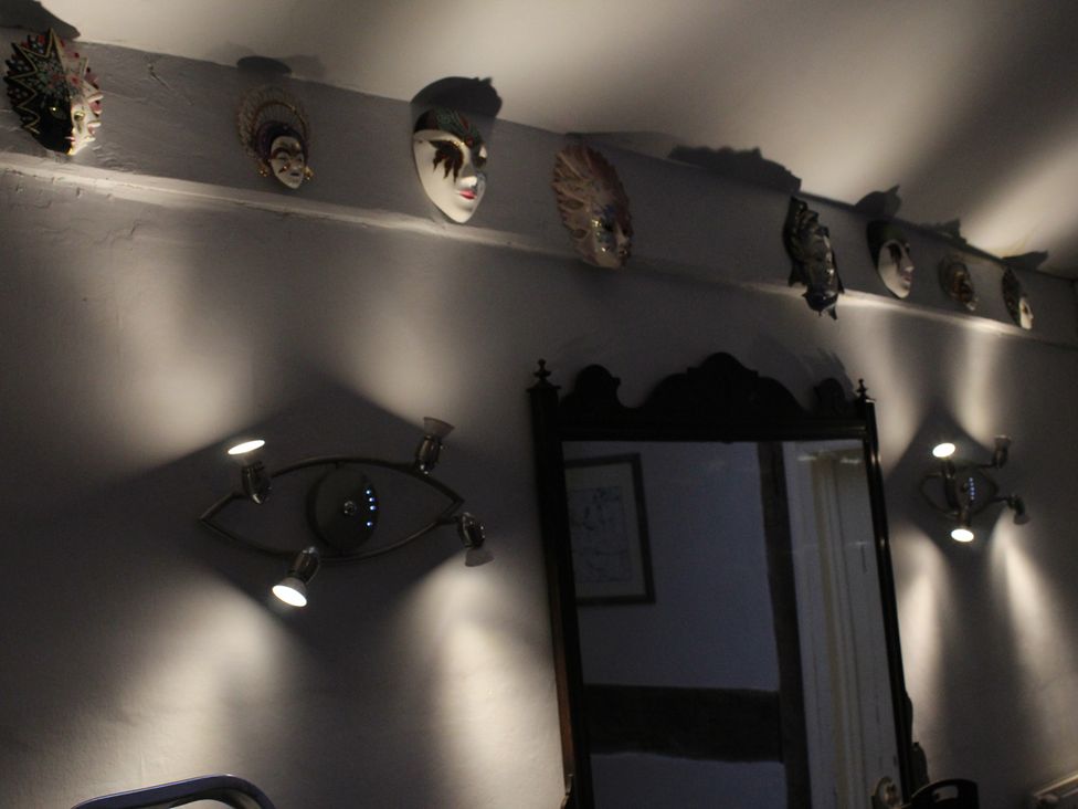 A wall with decorative masks and a mirror at 4BedHouse/Leominster/Hiking/Castles/Sleeps7/Wifi in Leominster