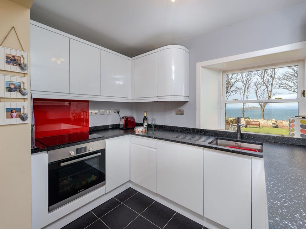 A kitchen with modern cabinets and a view of the sea at Charming Cottage in North Berwick