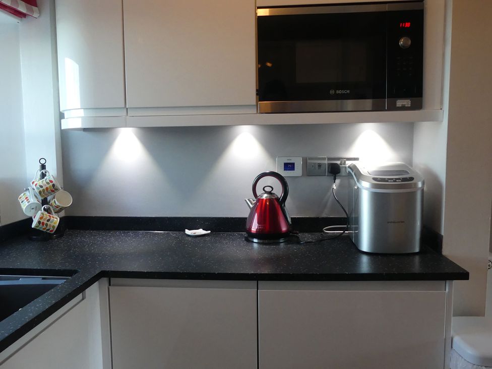 A kitchen with a microwave, kettle, and toaster at Charming Cottage in North Berwick
