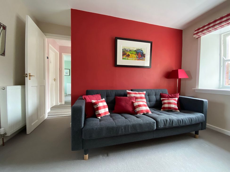 A living room with a sofa and artwork at Charming Cottage in North Berwick