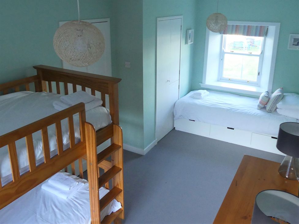 A bedroom with a bunk bed and a single bed at Charming Cottage in North Berwick