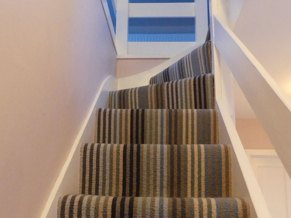 A staircase with carpet and a handrail at Charming Cottage in North Berwick
