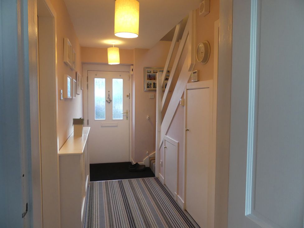 A hallway with a front door and staircase at Charming Cottage in North Berwick
