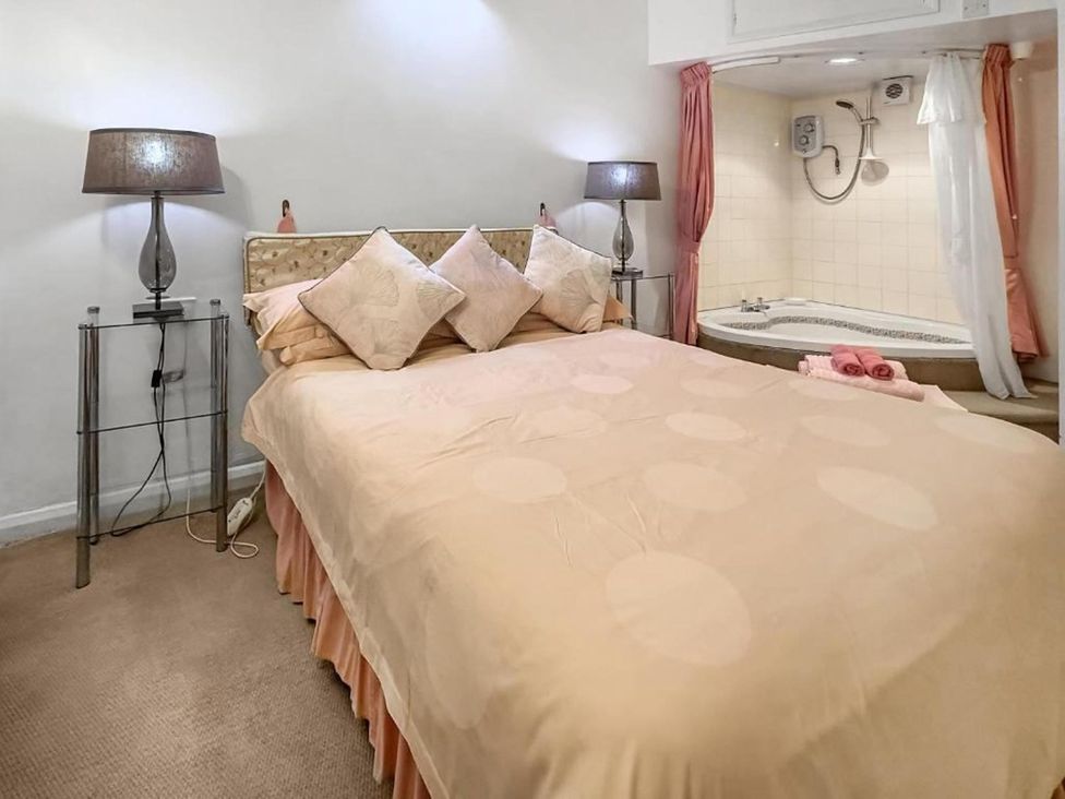 A bedroom with a bed and a whirlpool bath at Apartment Sleeps 2 with Parking, Pets Welcome Watermillock near Pooley Bridge